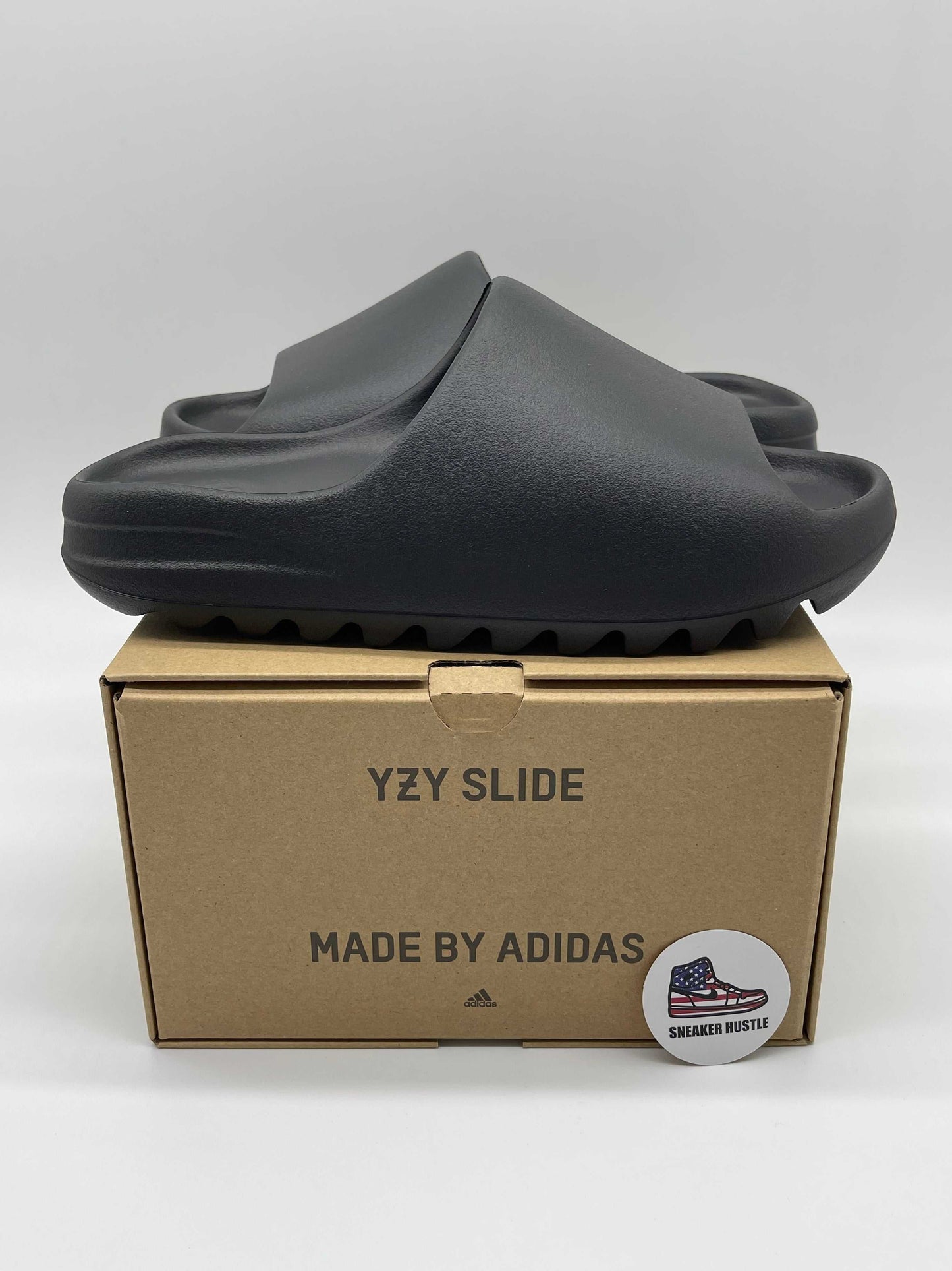 adidas Yeezy Slide Onyx black slip-on sandals on cardboard box