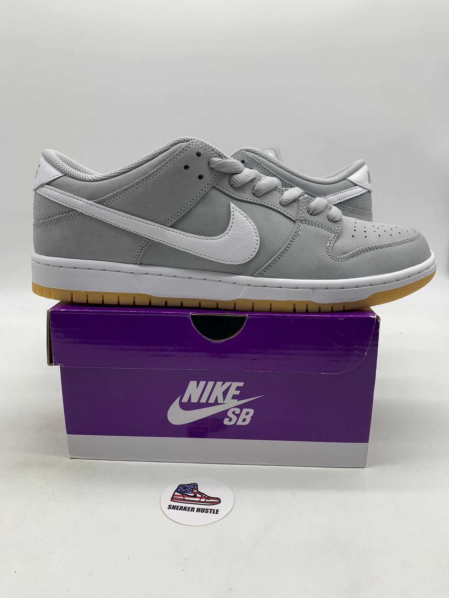 Nike SB Dunk Low Pro ISO sneaker in wolf grey with white swoosh and gum sole on purple Nike SB box
