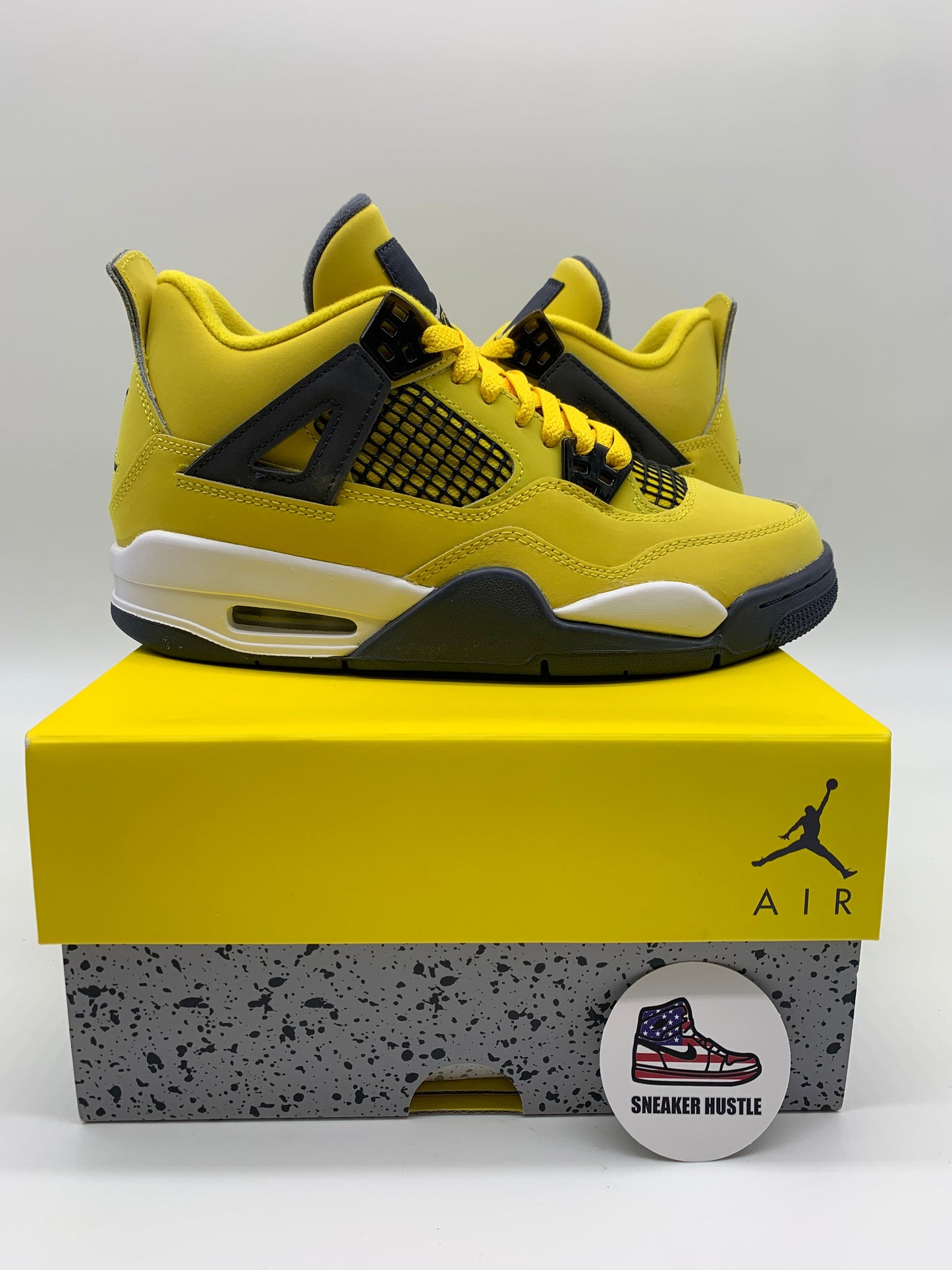 Jordan 4 Retro Lightning 2021 GS yellow and black sneakers on box