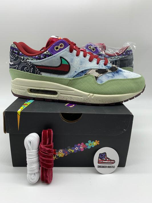 Nike Air Max 1 SP Concepts Mellow sneaker in multicolor with green suede, red laces, and paisley pattern design on black box with extra laces and pin badge