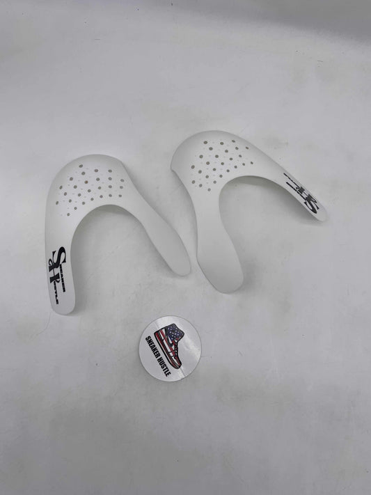 Pair of white Sneaker Hustle crease protectors with ventilation holes and logo on a white background